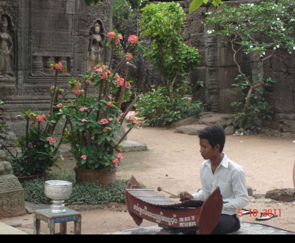 Young boy playing Cambodian Xylophone. Temple Ta Prohm, Takeo