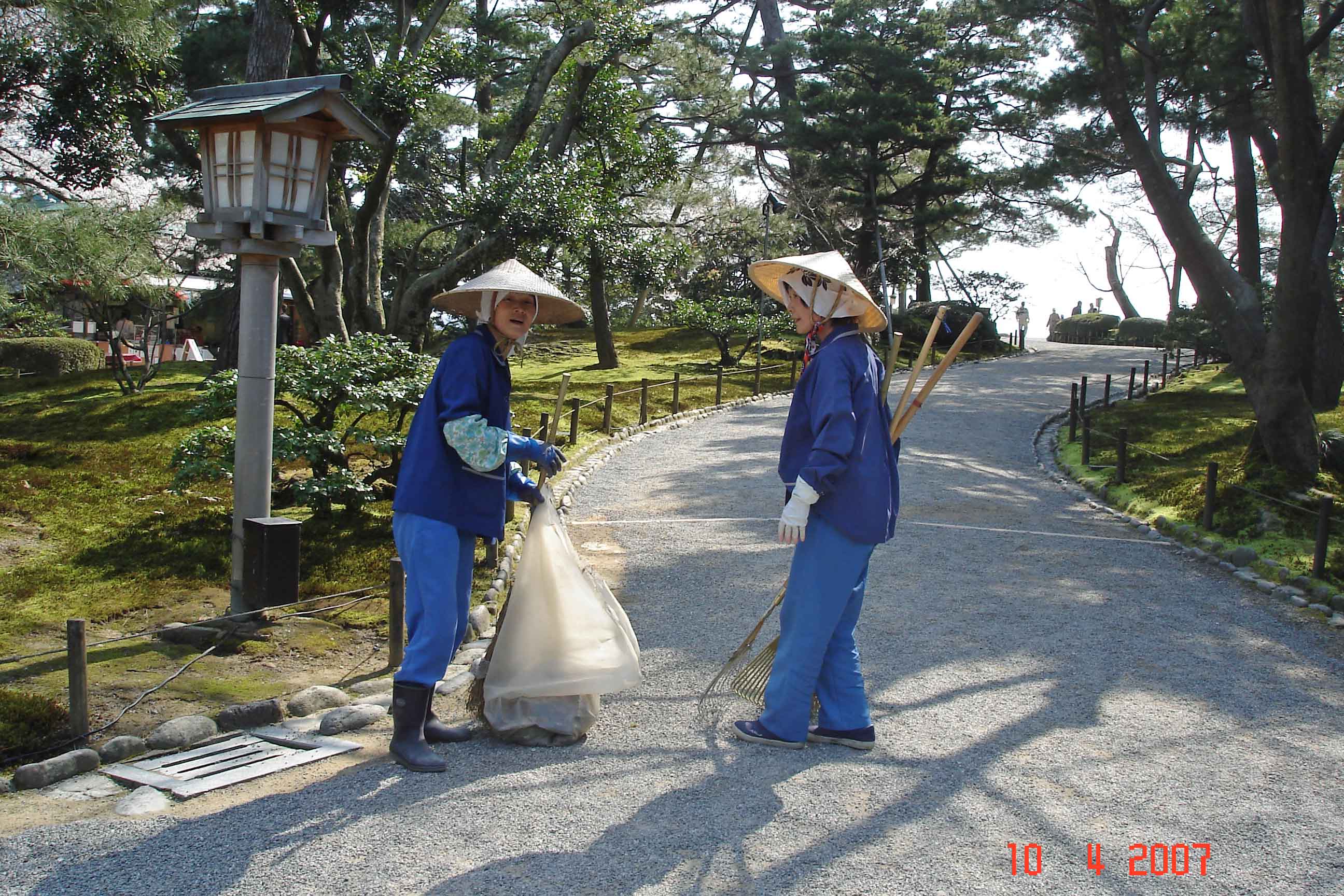 Japanese women tending paths in the park-Kenrokuen