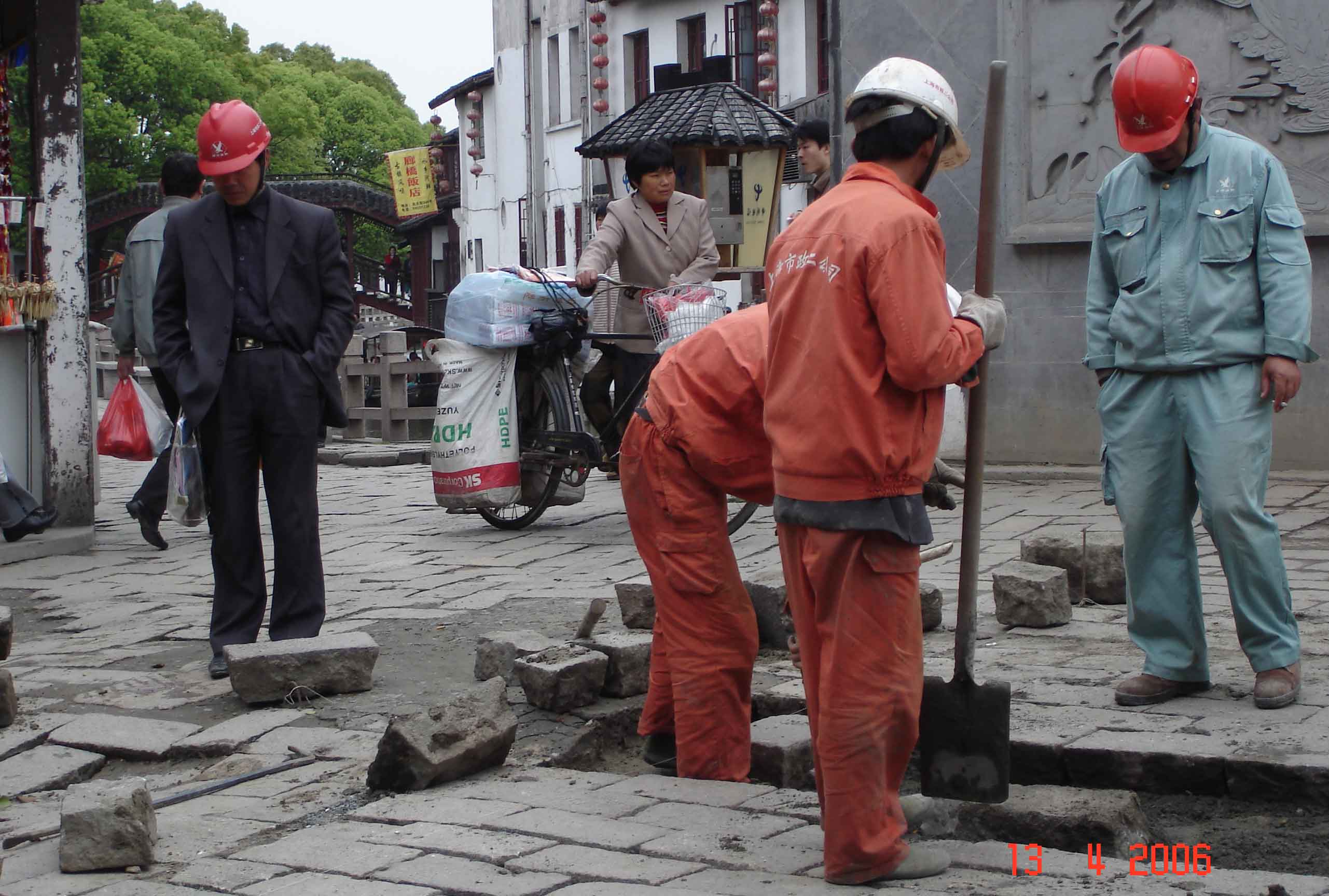 Workmen replacing pavement blocks outside City God Temple