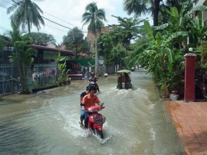 Motor-bikes-plow-through flow of water in main streets after rain